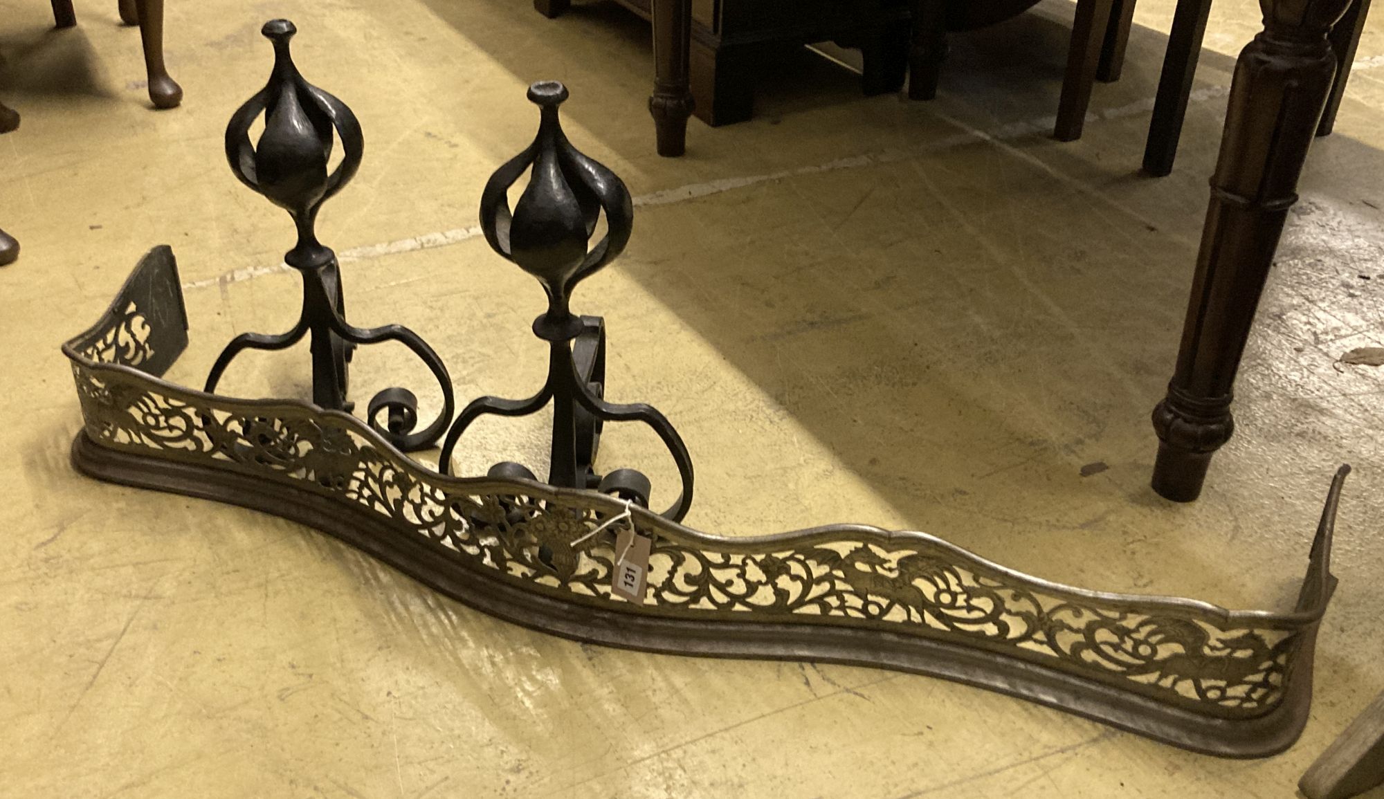 A George III pierced steel serpentine fender, length 130cm, together with a pair of wrought iron firedogs